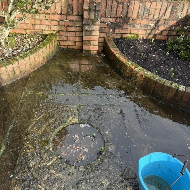 Patio with brick borders before cleaning by Owens Exterior Cleaning, Devon